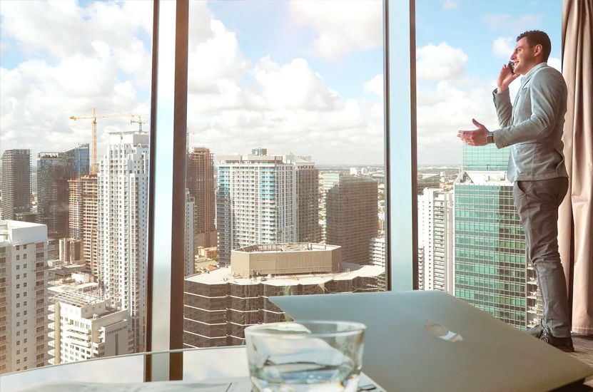 Man Standing in Office Building Window Man Standing in Office Building Window